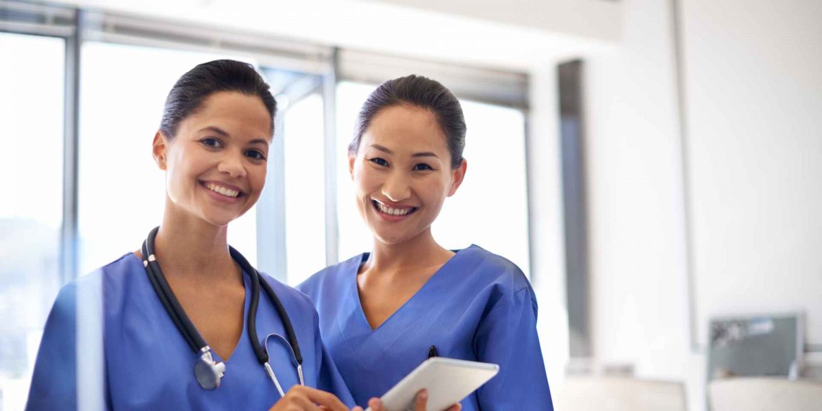 portrait-of-two-female-nurses-standing-with-a-digi-2023-11-27-05-19-07-utc